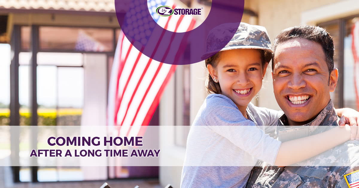 Man in military fatigues smiling and hugging young girl