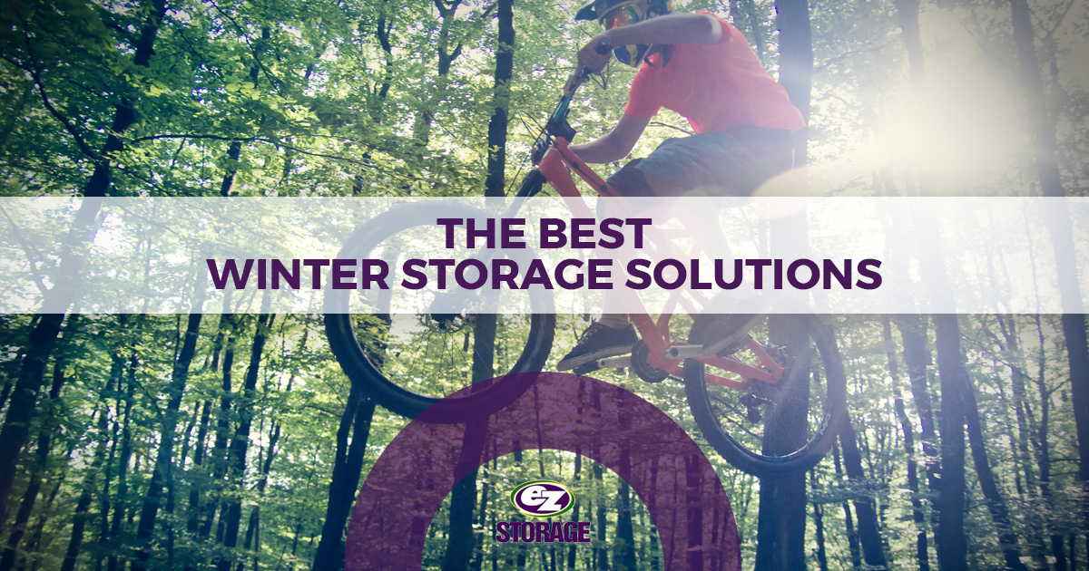 Mountain biker riding through forest with EZ Storage logo and text "The Best Winter Storage Solutions"