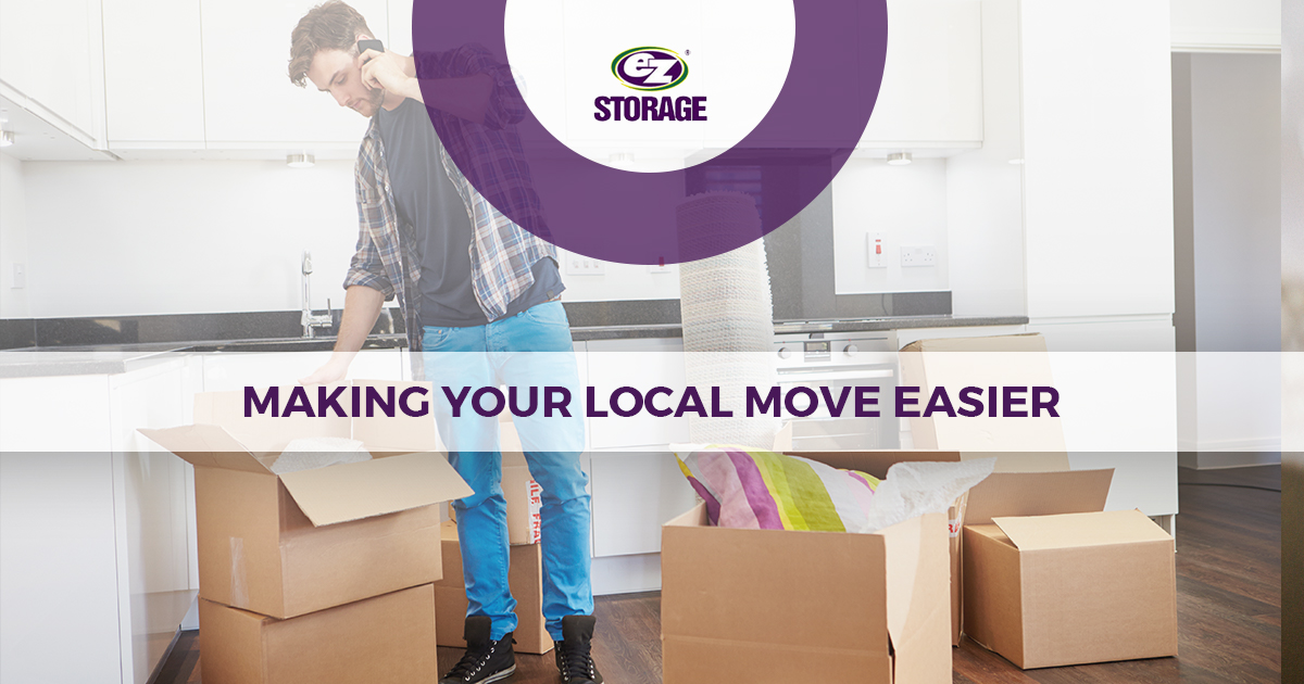 Man on his cellphone unpacking boxes in the kitchen and text "Making your local move easier"