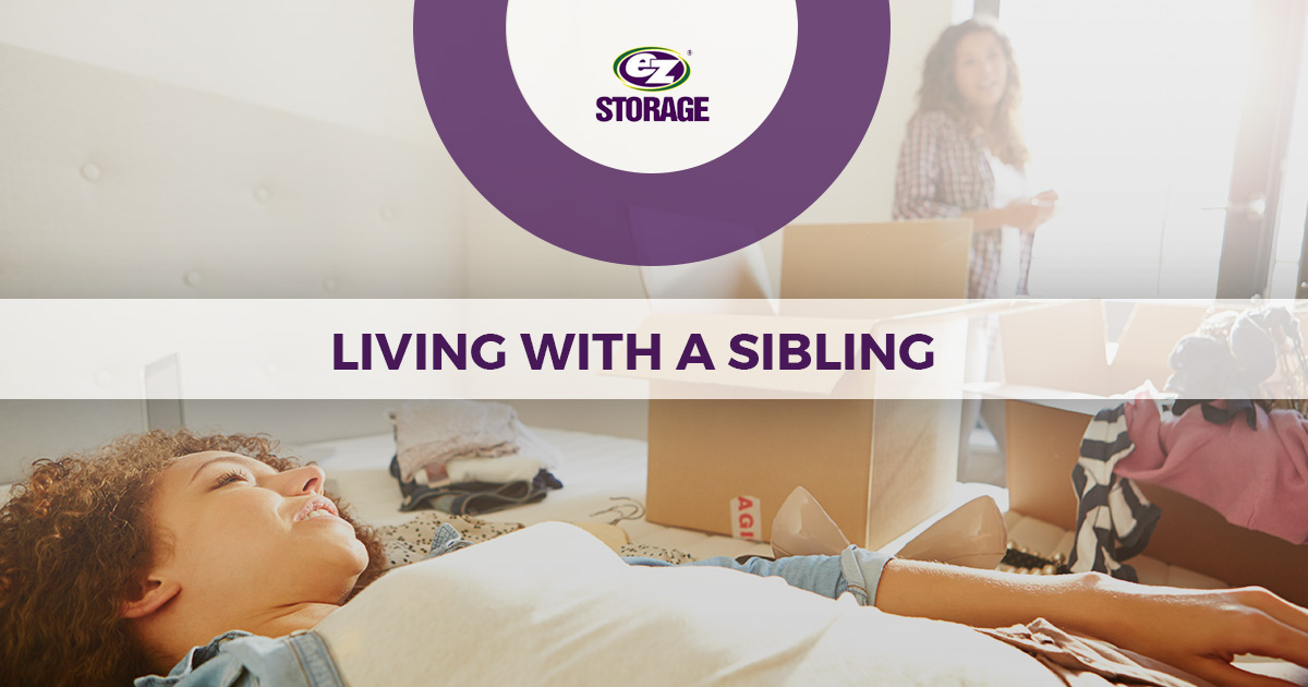 Two sisters smiling unpacking boxes and text "Living with a sibling"