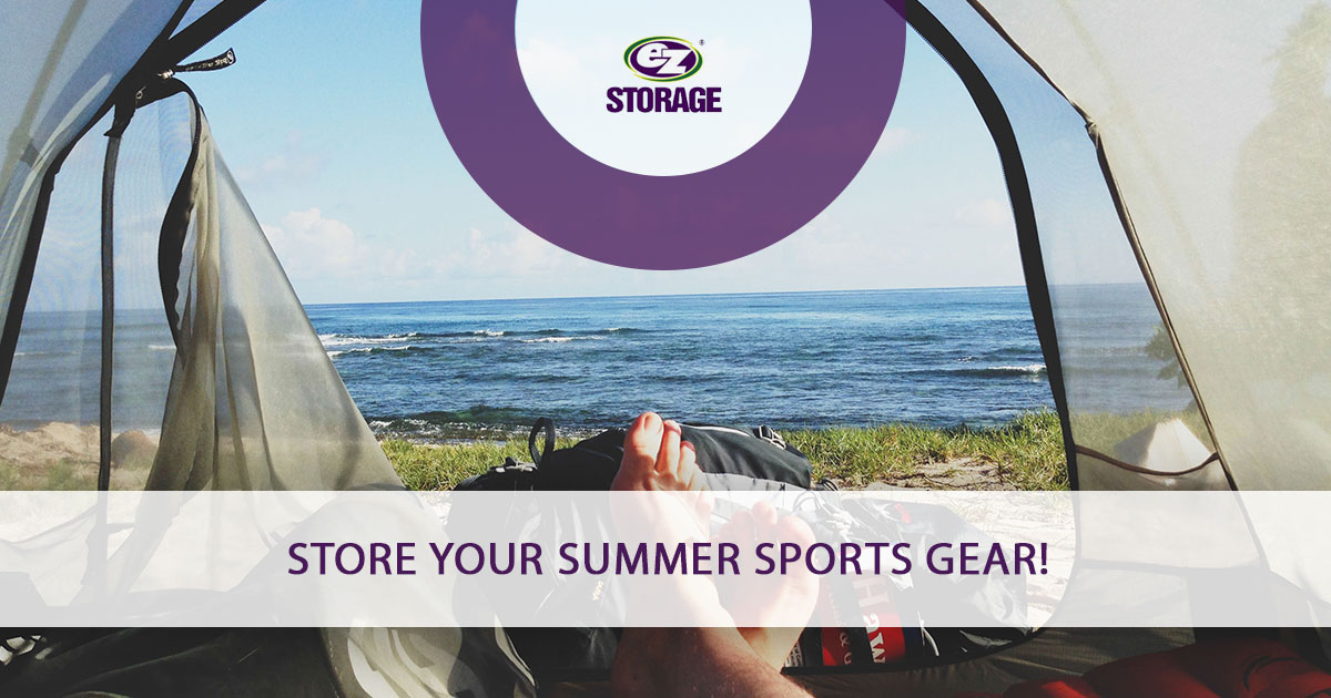 Open camping tent overlooking lake with EZ Storage logo and text "Store Your Summer Sports Gear!"