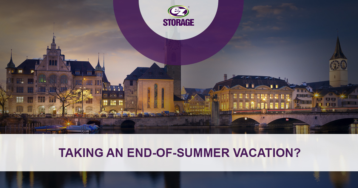 Row of buildings lit up at nighttime with EZ Storage logo and text "Taking An End-of-Summer Vacation?"