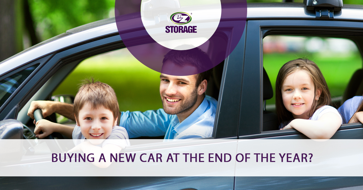 Father and two children inside car smiling and text "Buying a new car at the end of the year?"