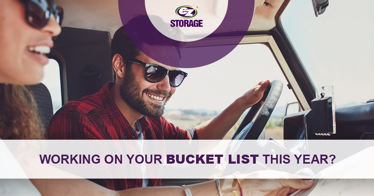 Couple wearing sunglasses in a car reading a map smiling and text "Working on your bucketlist this year?"