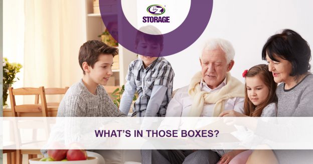 Grandparents with children in living room with banner text "What's in those boxes?"