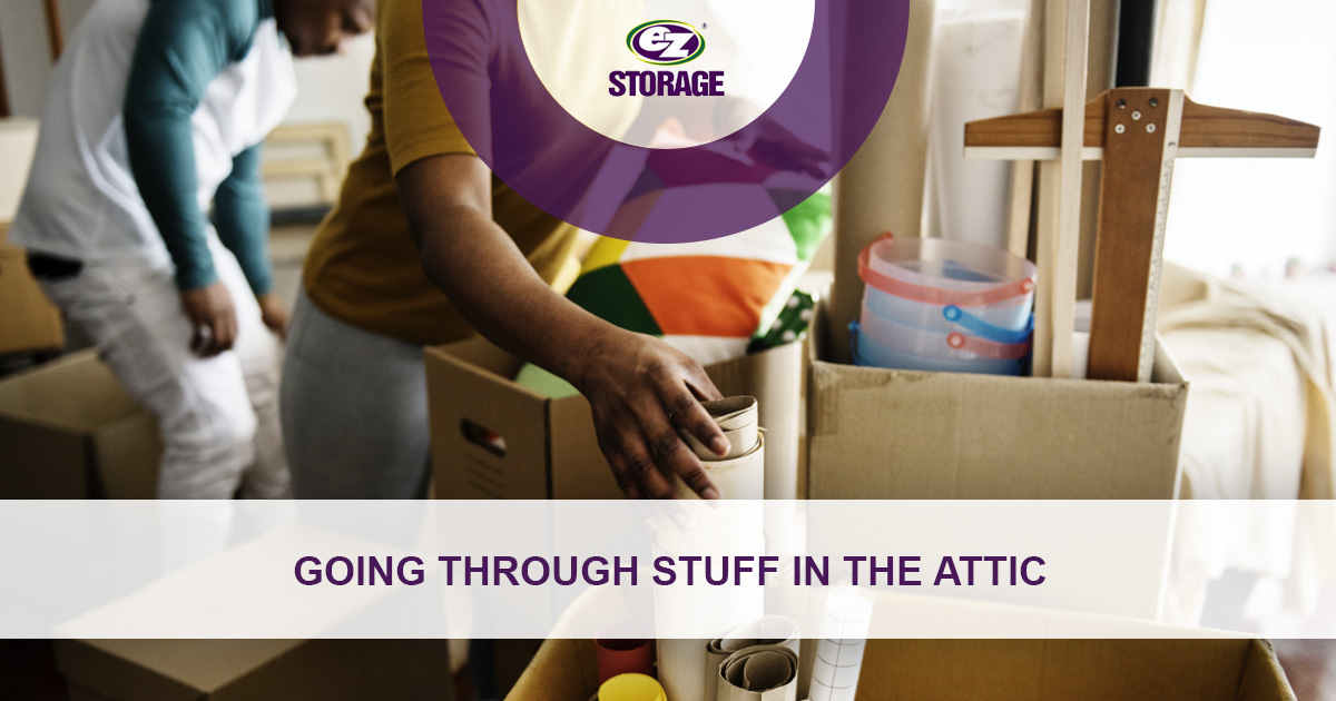 Two people looking through open boxes and text "Going through stuff in the attic"