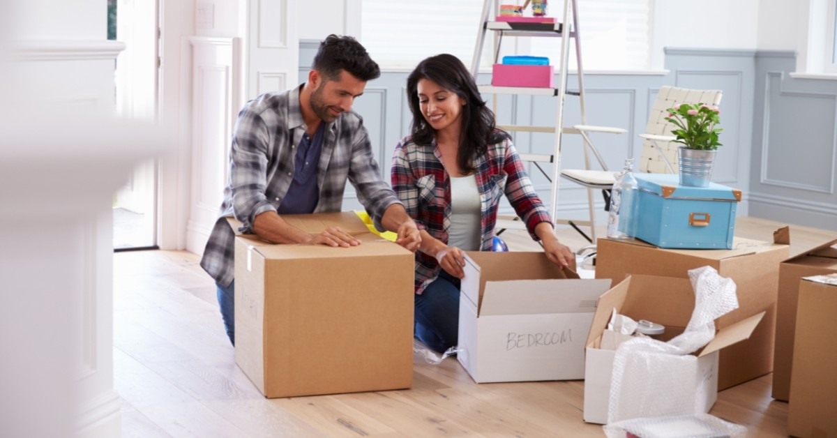 Man and woman packing up moving boxes