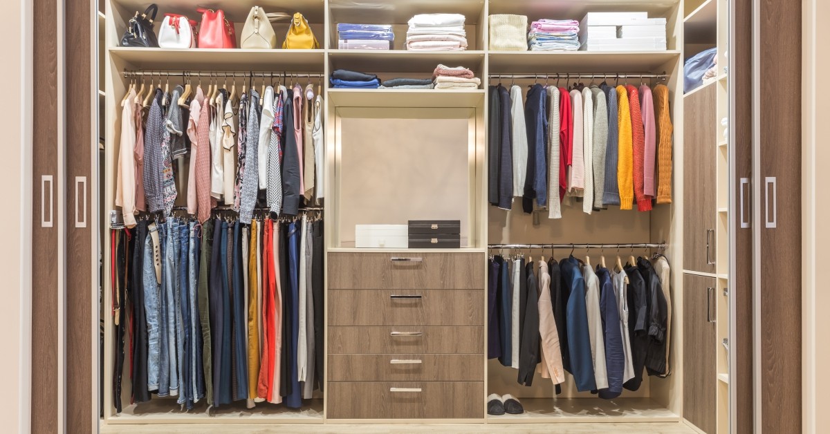 Walk in closet with clothes hanging from racks