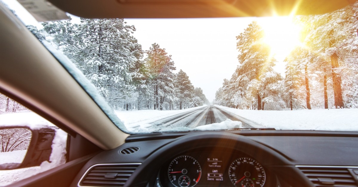 View from driver seat of car facing out onto road with snow