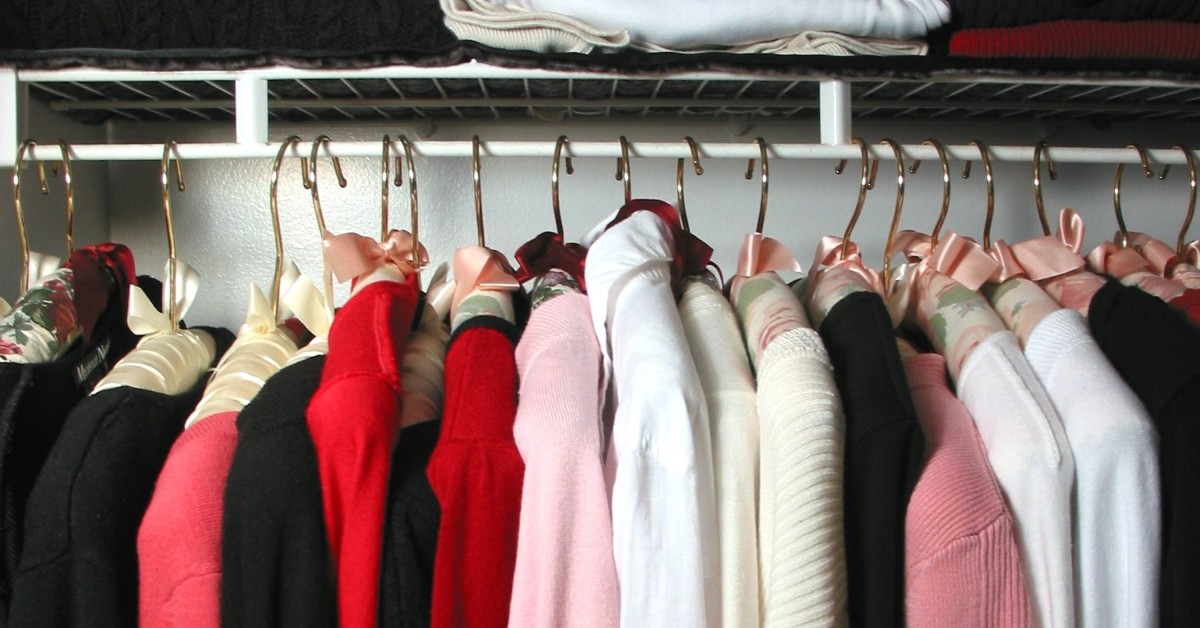 Interior of a closet with feminine garments hanging on closet rack.