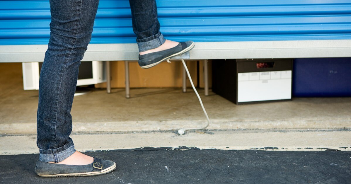 Close up of woman's foot pushing closed a storage unit door.