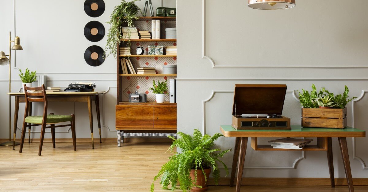 Interior view of apartment living space with desk, typewriter and vintage wall decor.