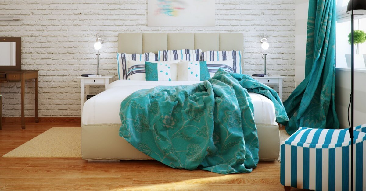 Bedroom scene in efficiency apartment with exposed brick wall and teal & white color scheme