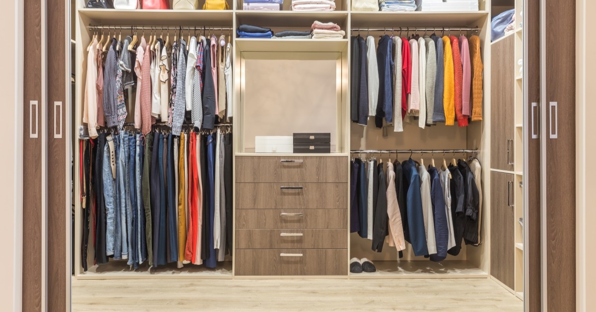 Organized walk-in closet with clothing on hangers