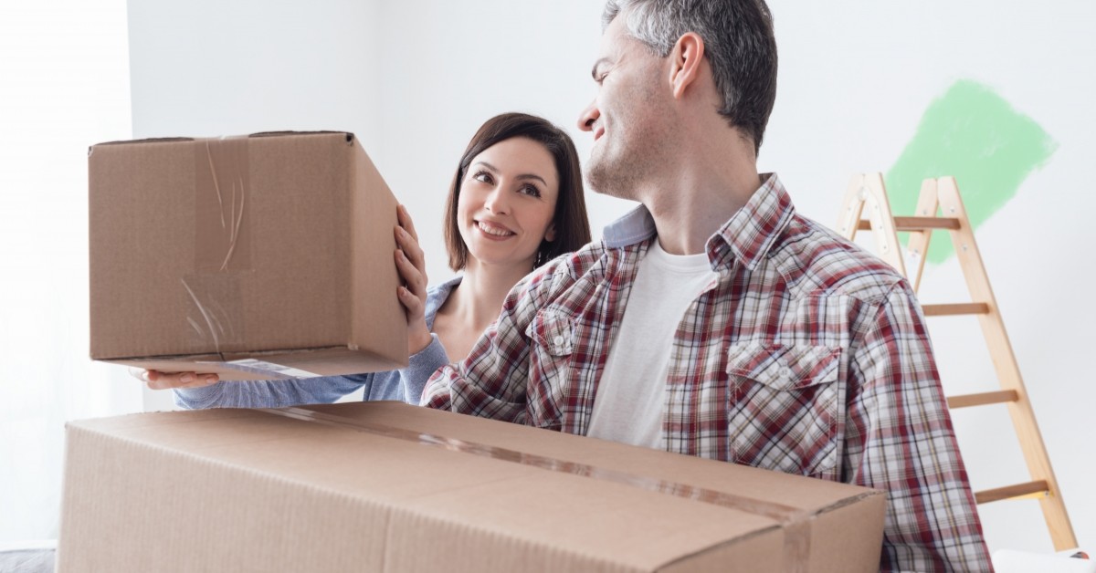 Couple stacking moving boxes