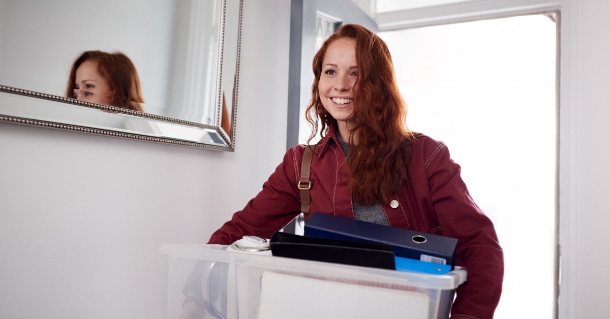 Woman carrying packed tote box