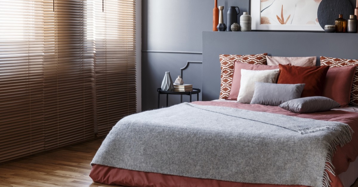 A bedroom view of a bed with decorated pillows and a nightstand